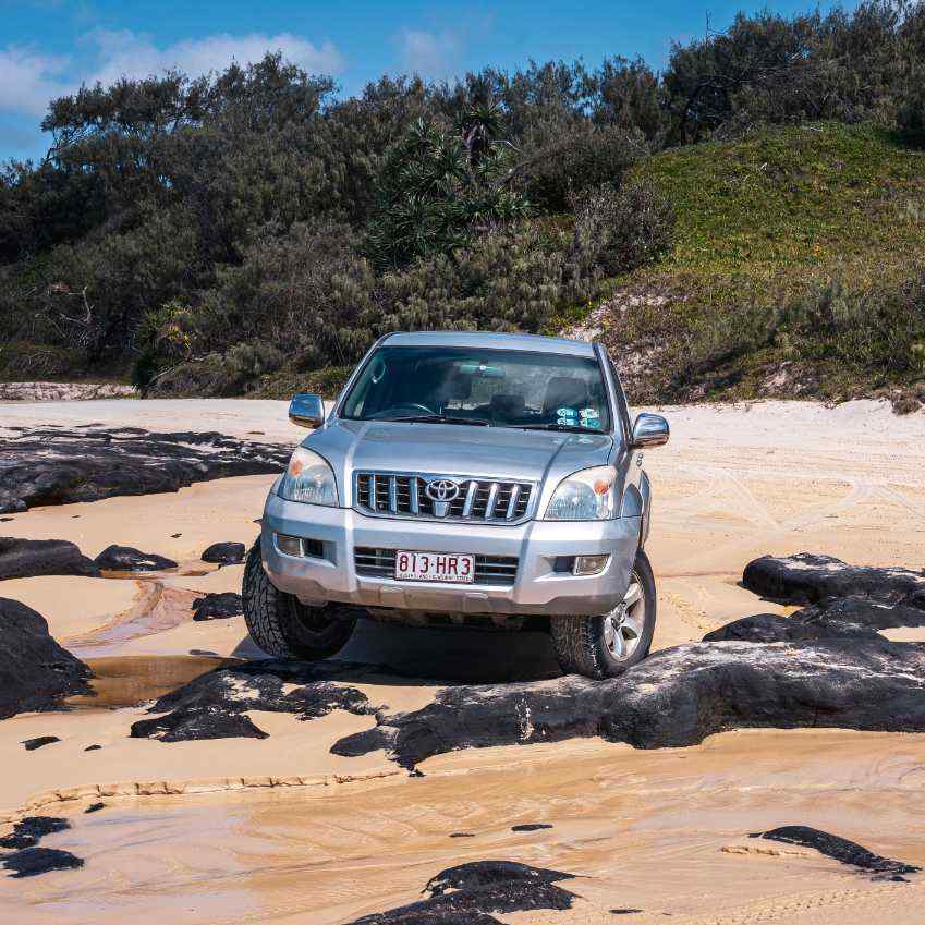 4WD hire vehicle driving on K’gari’s beach.