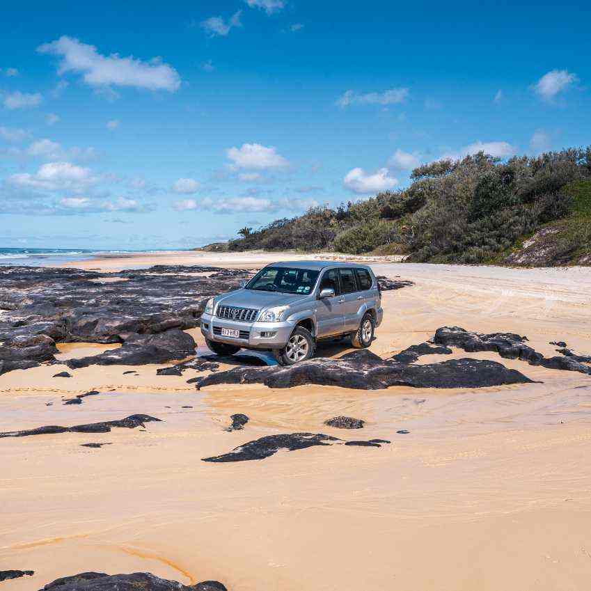 Beachside 4WD on rocks and sand at K’gari.